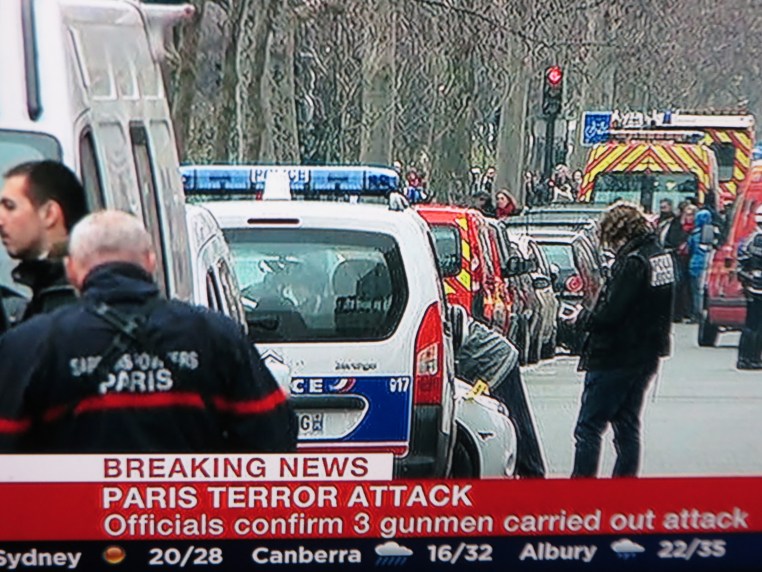 The BBC World Service Announces that the French Police are seeking three suspects in the Charlie Hebdo attack within hours   of the  event. This shot was taken around six hours after the attack.