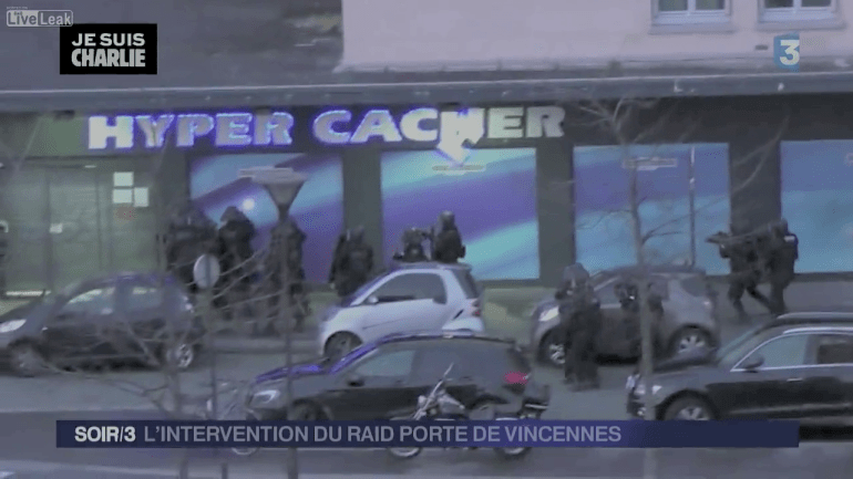 Police outside Hyper Cacher Supermarket. Doors closed. Shutter down. 