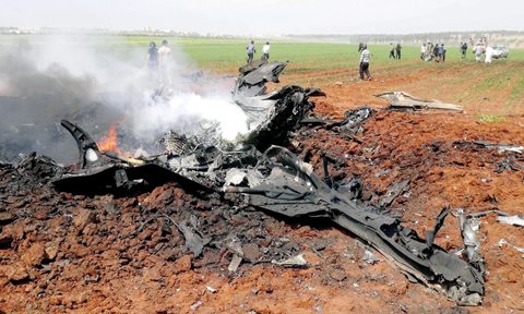 Flattened Su22 lies in the fields of Aleppo yesterday.
